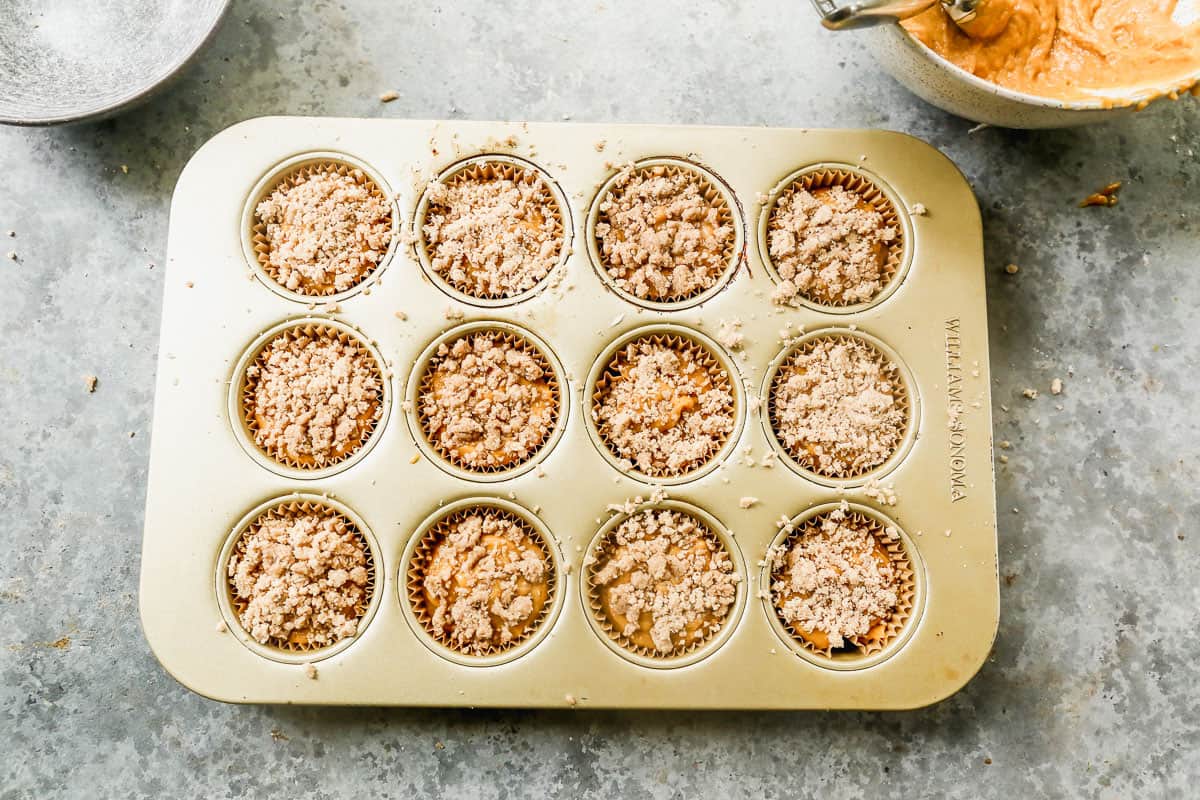 Easy pumpkin cream cheese muffins with streusel in a muffin pan, ready to bake.