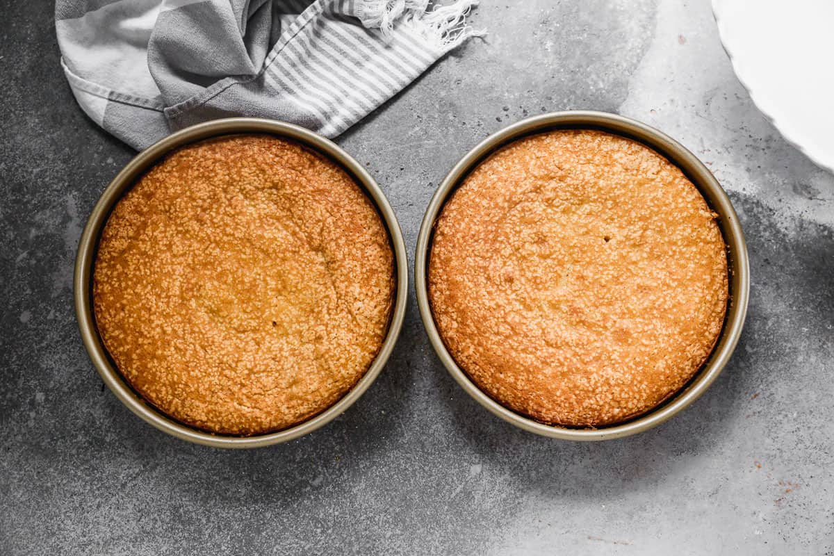 Two cake pans filled with freshly baked Yellow Cake, golden brown.
