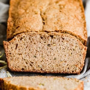 A loaf of zucchini bread with a slice cut from it.