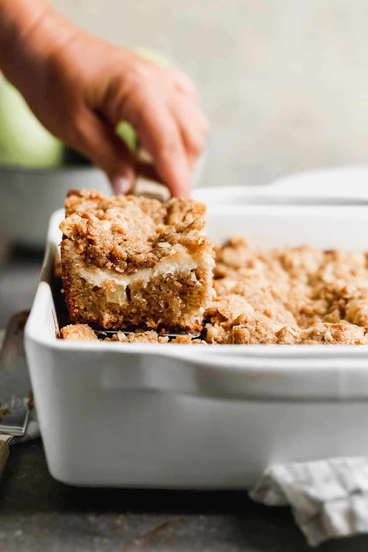 A square of easy Apple Coffee Cake being lifted from the pan to show the layers inside.