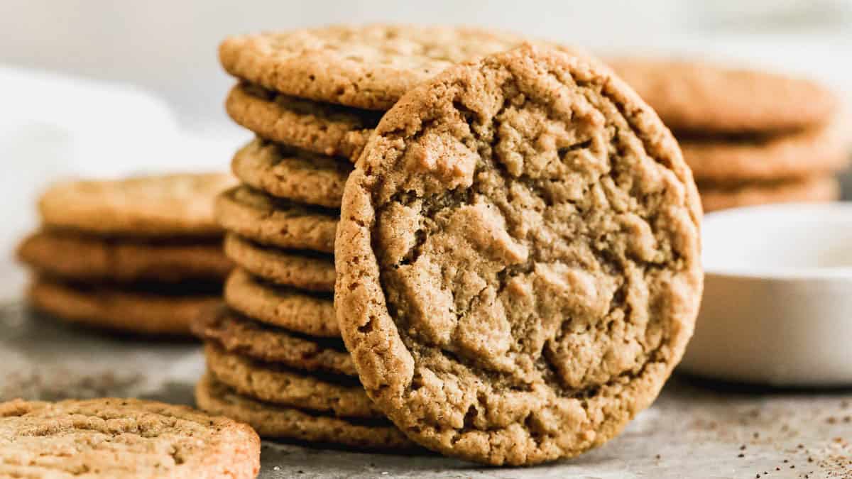 A stack of homemade Gingersnap Cookies with one cookie leaning against the stack.