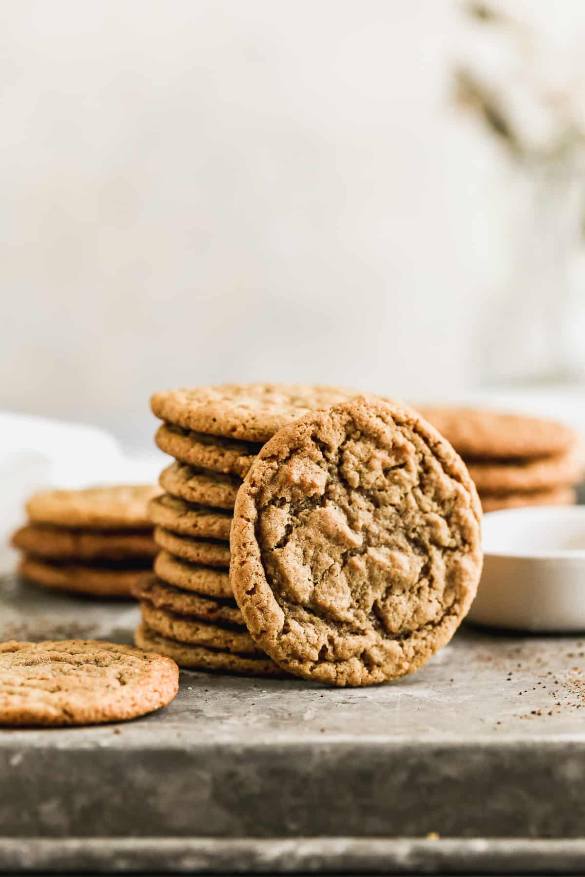 A stack of homemade Gingersnap Cookies with one cookie leaning against the stack.
