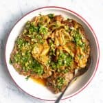 Italian Osso Buco recipe on a plate, garnished with gremolata on top.
