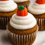 A moist Pumpkin Cupcake frosted with cinnamon cream cheese and topped with a candy pumpkin.