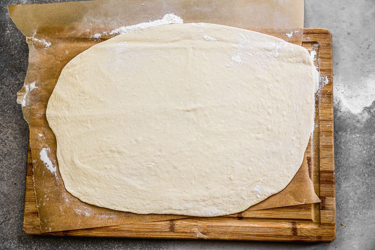Pizza dough rolled into a large rectangle.