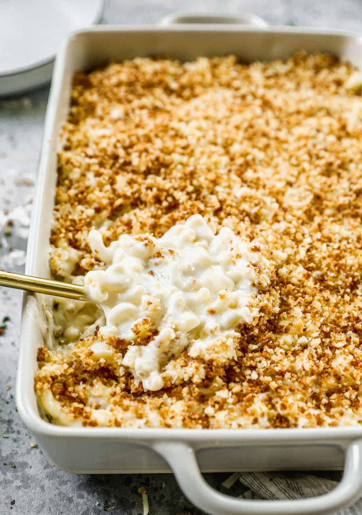 A simple Truffle Mac and Cheese recipe freshly baked and a spoonful being scooped.