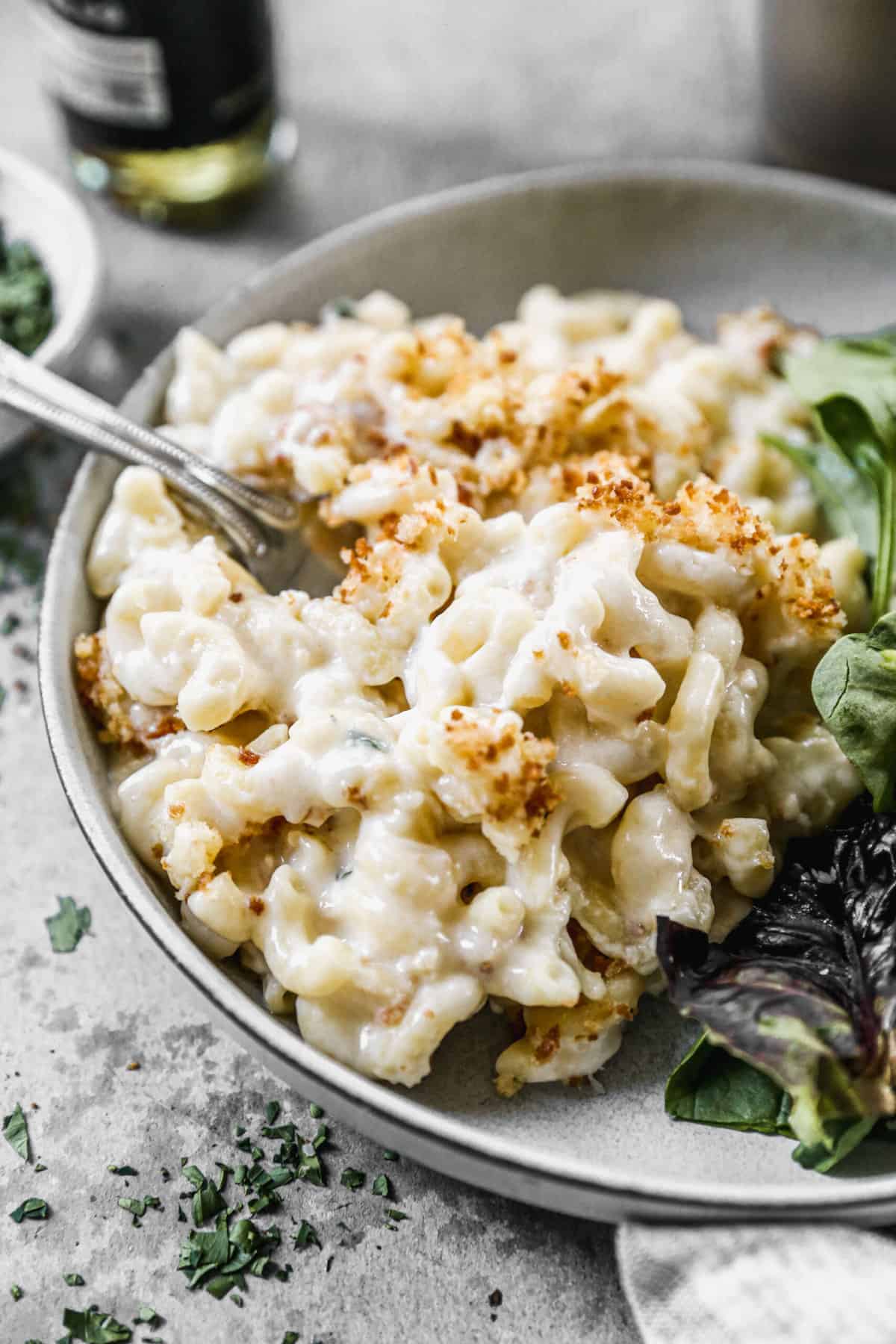 Truffle macaroni and cheese served on a plate with a green salad.