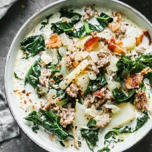 Save this creamy Zuppa Toscana recipe for a cozy homemade dinner. Italian sausage, potatoes, kale, bacon, and cream make a hearty soup with Olive Garden-inspired flavor. Includes stovetop, slow cooker, Instant Pot, and make-ahead instructions.