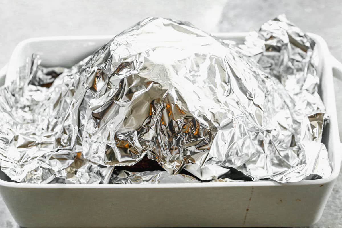 The best baked ham recipe in a baking dish, covered with tinfoil before it's baked.