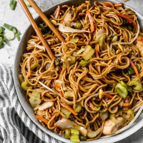 A bowl with an easy Chow Mein recipe with chicken and veggies, with chopsticks.