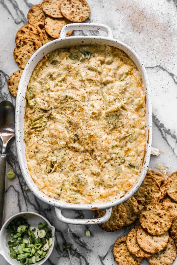 The best Crab Artichoke Dip in an oval pan, fresh out of the oven.