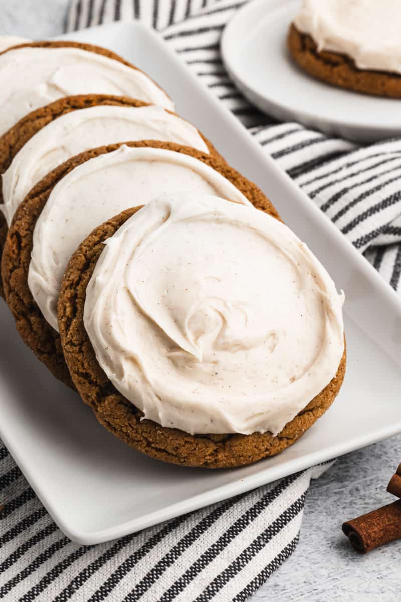 Soft and chewy ginger molasses cookies on a plate, leaning against each other.