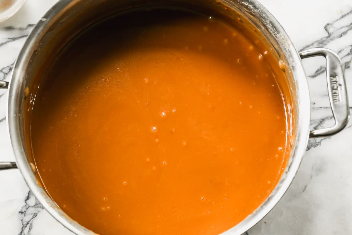 A pot of easy homemade caramel, golden brown.