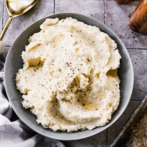 A bowl of homemade Mashed Potatoes with salt and pepper sprinkled on top.