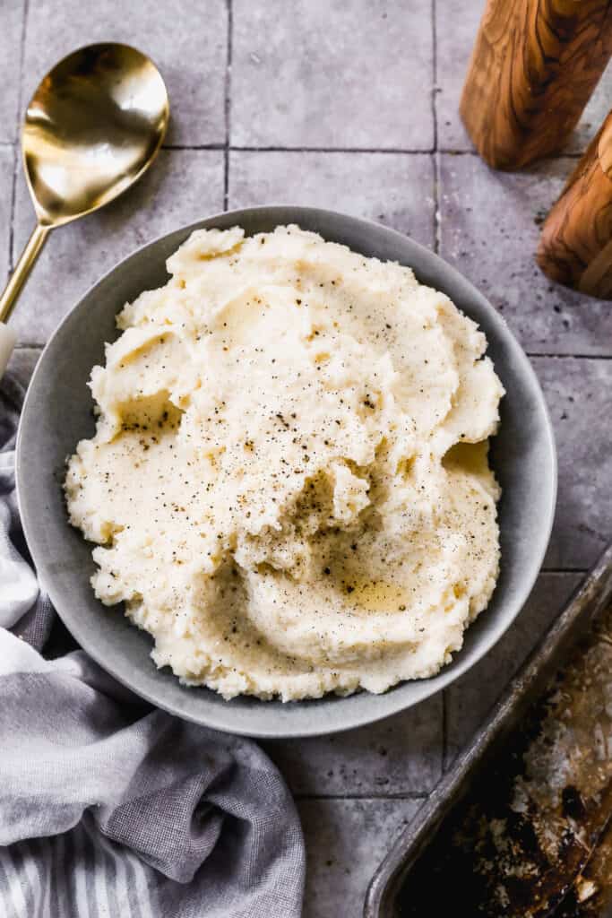 A bowl of homemade Mashed Potatoes with salt and pepper sprinkled on top.