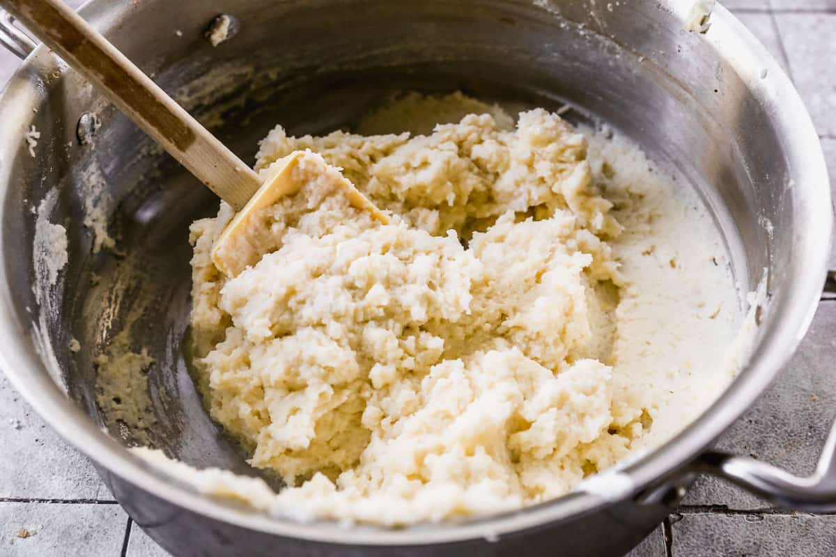 Mashed Potatoes being stirred with a rubber spatula. 