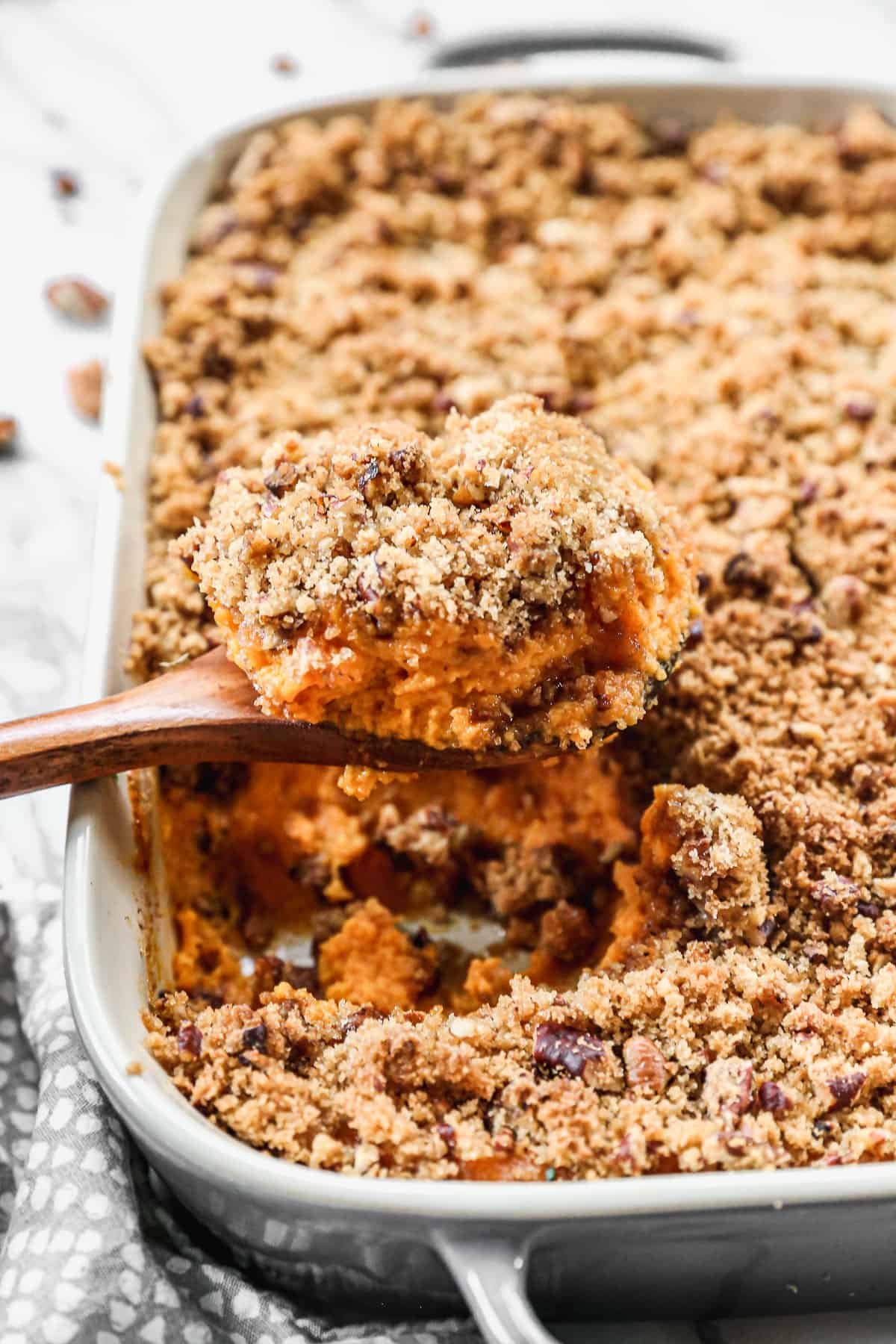 A piece of the best Sweet Potato Casserole recipe being lifted out of a rectangle pan to serve.