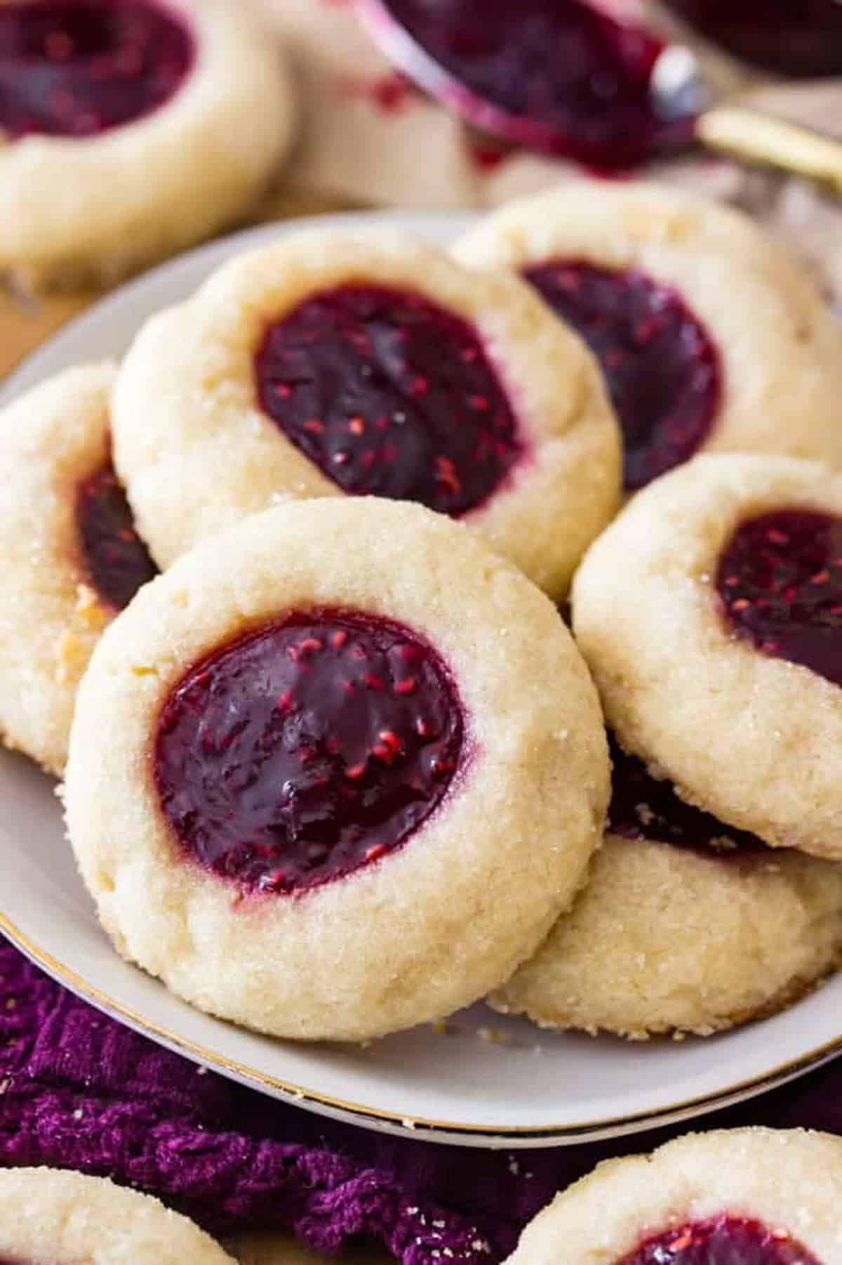 Homemade Jam Thumbprint Cookies on a plate, with raspberry jam in the middle of each.