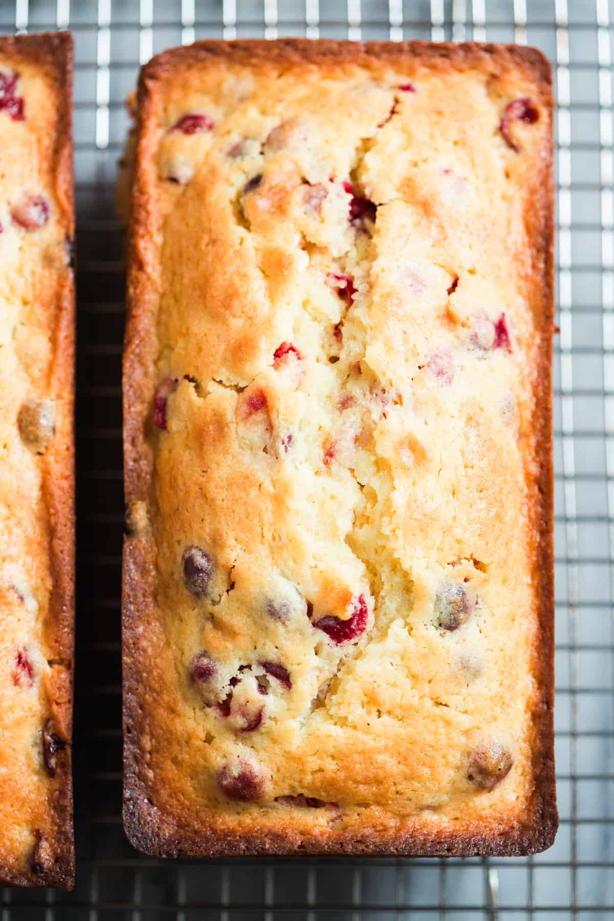 A loaf of the best Cranberry Orange Bread on a cooling rack.