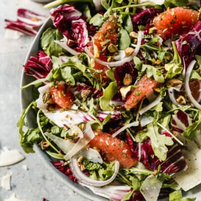 A simple Radicchio Salad in a bowl with romaine, arugula, grapefruit slices, and a homemade vinaigrette.