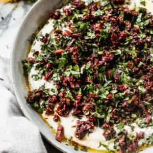 Whipped goat cheese with chopped sun-dried tomatoes, kalamata olives, basil, and oregano on top to make a delicious dip.