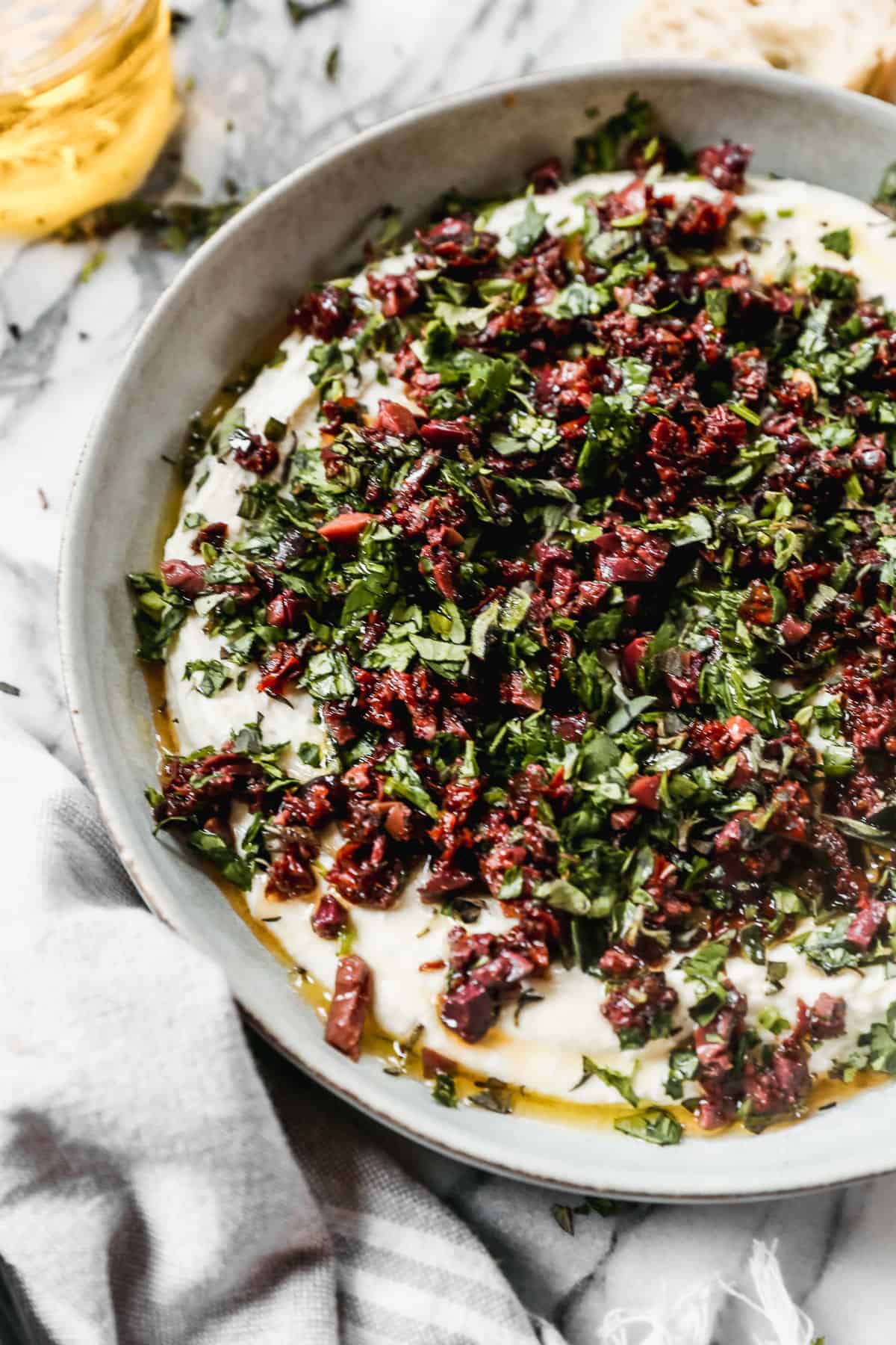 Whipped goat cheese with chopped sun-dried tomatoes, kalamata olives, basil, and oregano on top to make a delicious dip. 