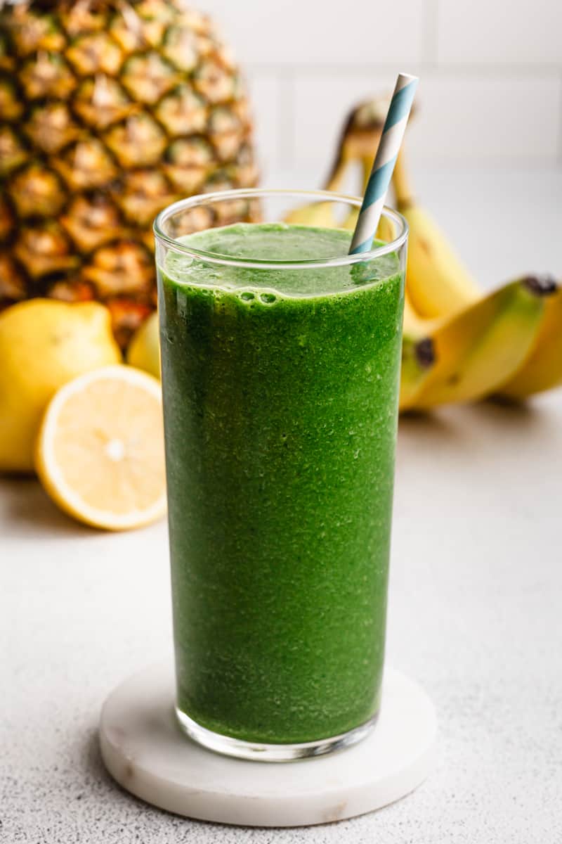 The best Green Smoothie recipe in a glass, ready to be enjoyed with a straw.