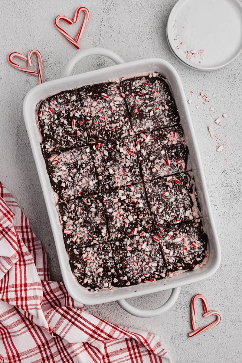 A pan of easy Peppermint Brownies recipe, topped with chocolate and crushed candy canes.