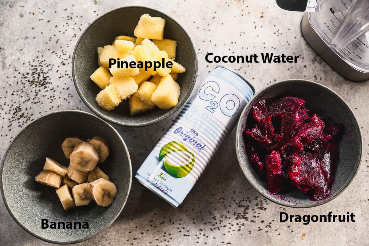 All of the ingredients you need for a homemade Pitaya Bowls recipe: pineapple, banana, coconut water, and dragon fruit.