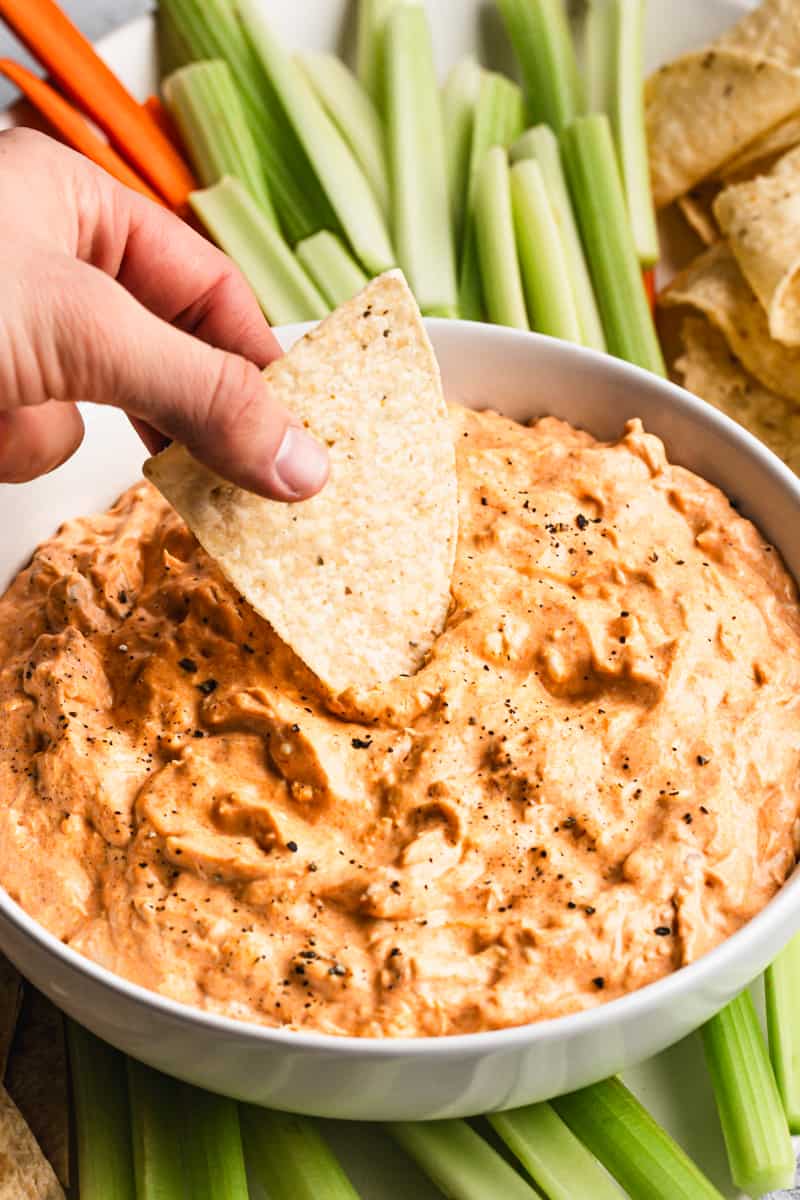 A chip being dipped in homemade Buffalo Chicken Dip.