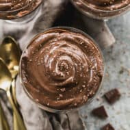 A homemade Chocolate Pudding recipe divided into individual trifle cups and topped with chocolate shavings.