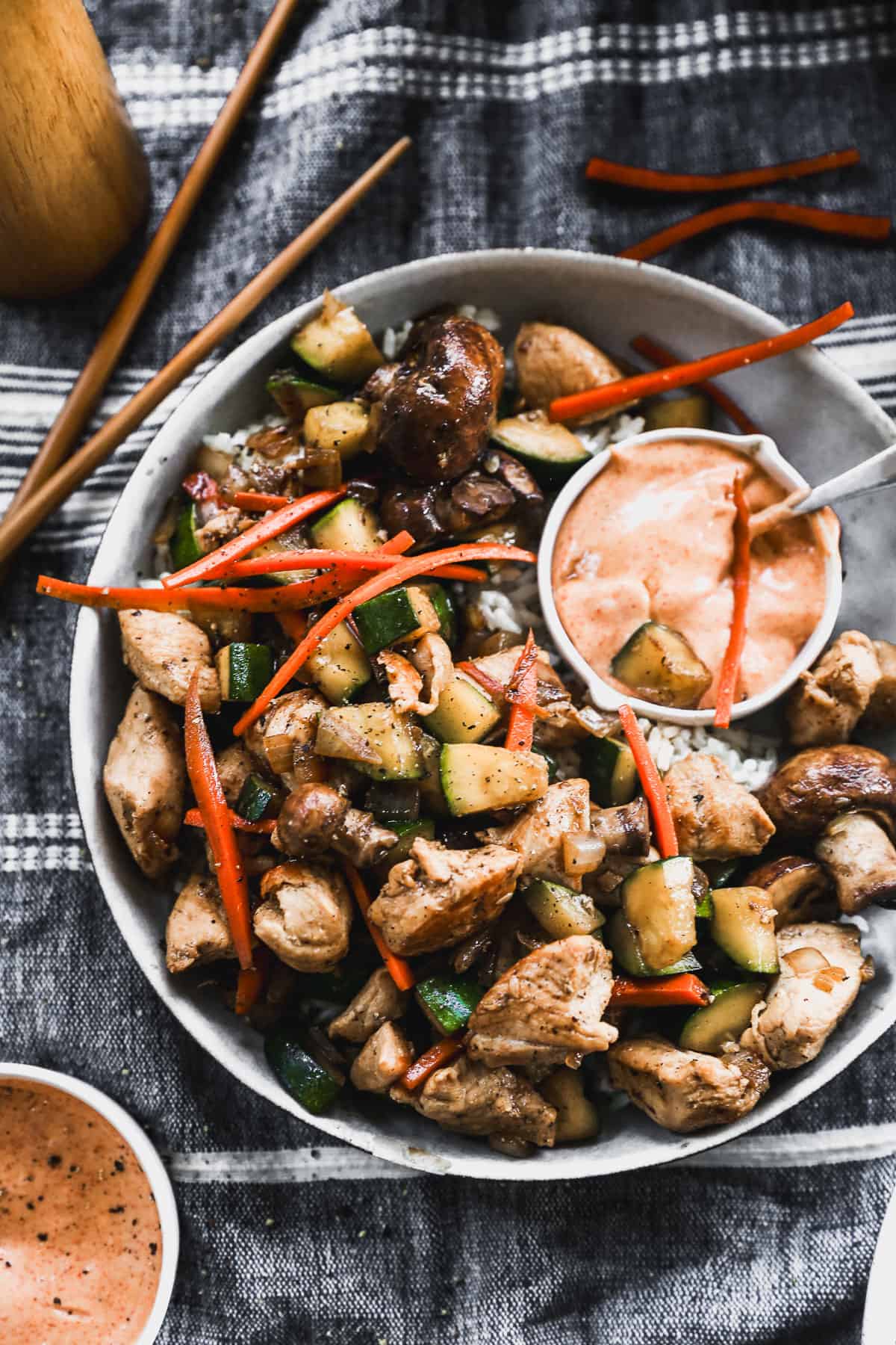 An easy Hibachi Chicken recipe with vegetables on a plate served over rice and with a side of homemade Yum Yum sauce.