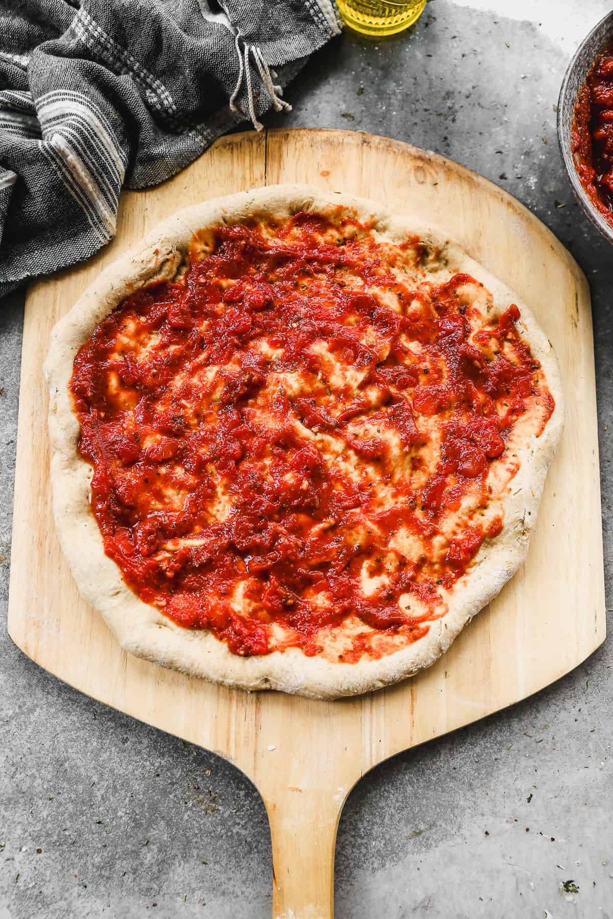 The best pizza sauce recipe spread on a homemade pizza crust.