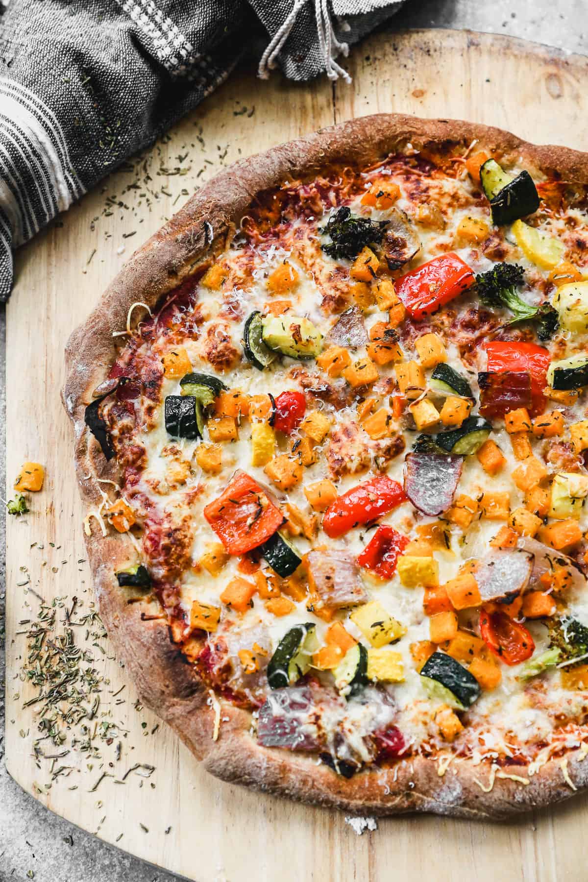 Homemade wheat pizza dough topped with pizza sauce, cheese, and a variety of vegetables.