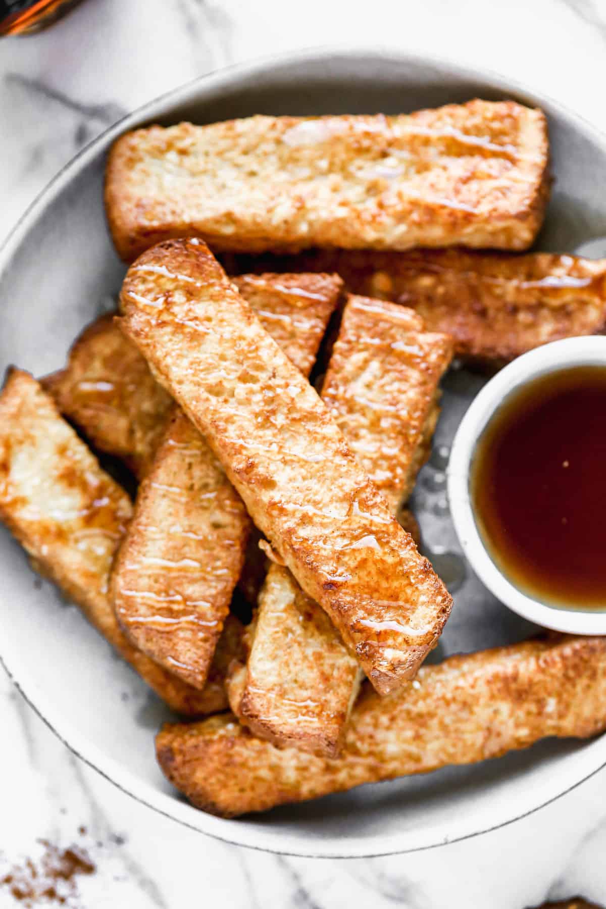 A delicious french toast stick recipe, all on a plate ready to enjoy.
