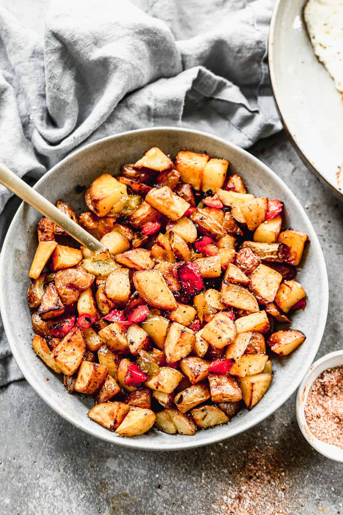 A bowl of crispy Breakfast Potatoes with bell peppers and onion, ready to serve.