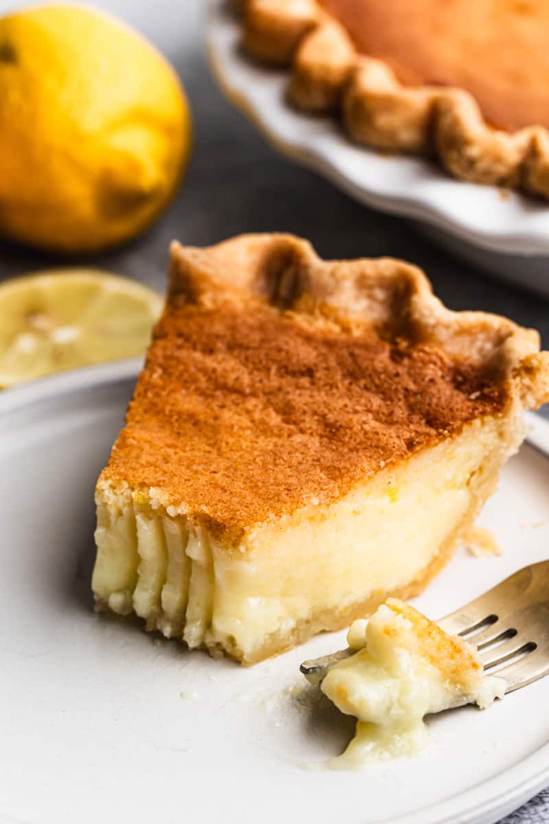A basic Chess Pie on a plate with a bite taken out by a fork.