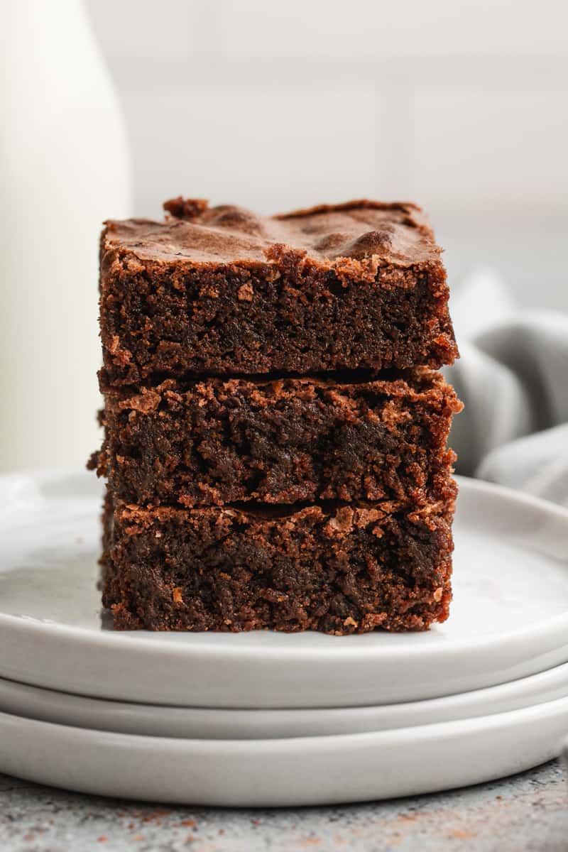 Three fudgy brownies stacked on top of each other, showing the perfect chewy texture.