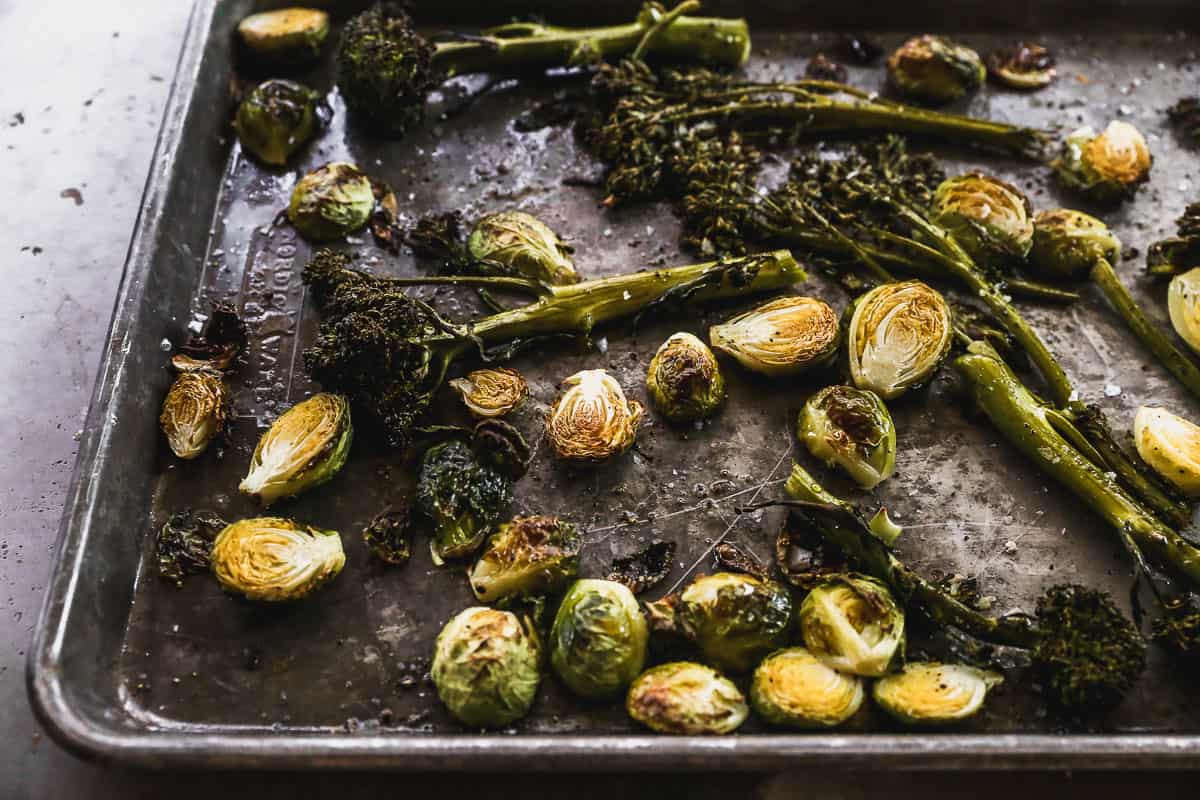 A sheet pan with roasted broccolini and brussels sprouts. 