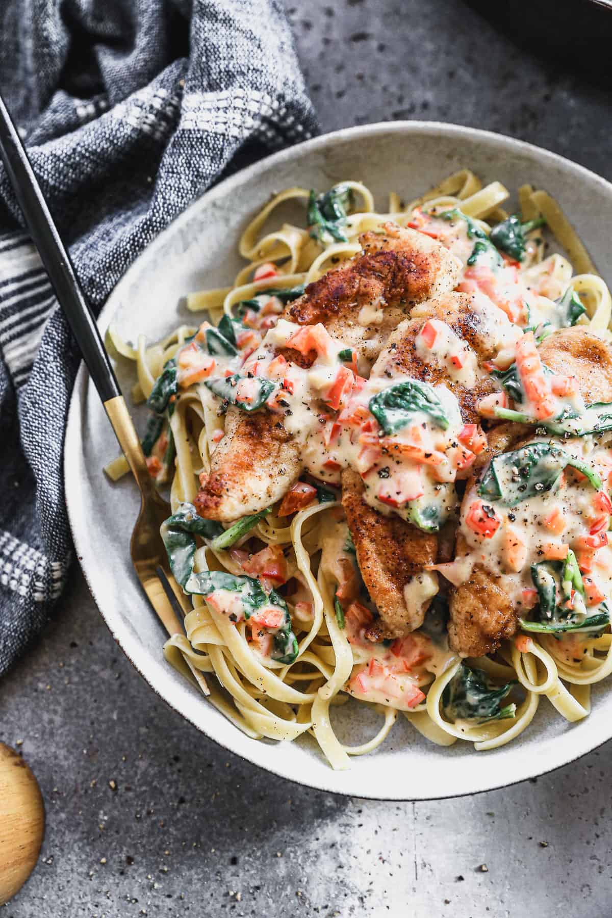 A close up image of an easy tuscan chicken pasta recipe with golden chicken tenders in a creamy sauce, ready to enjoy.