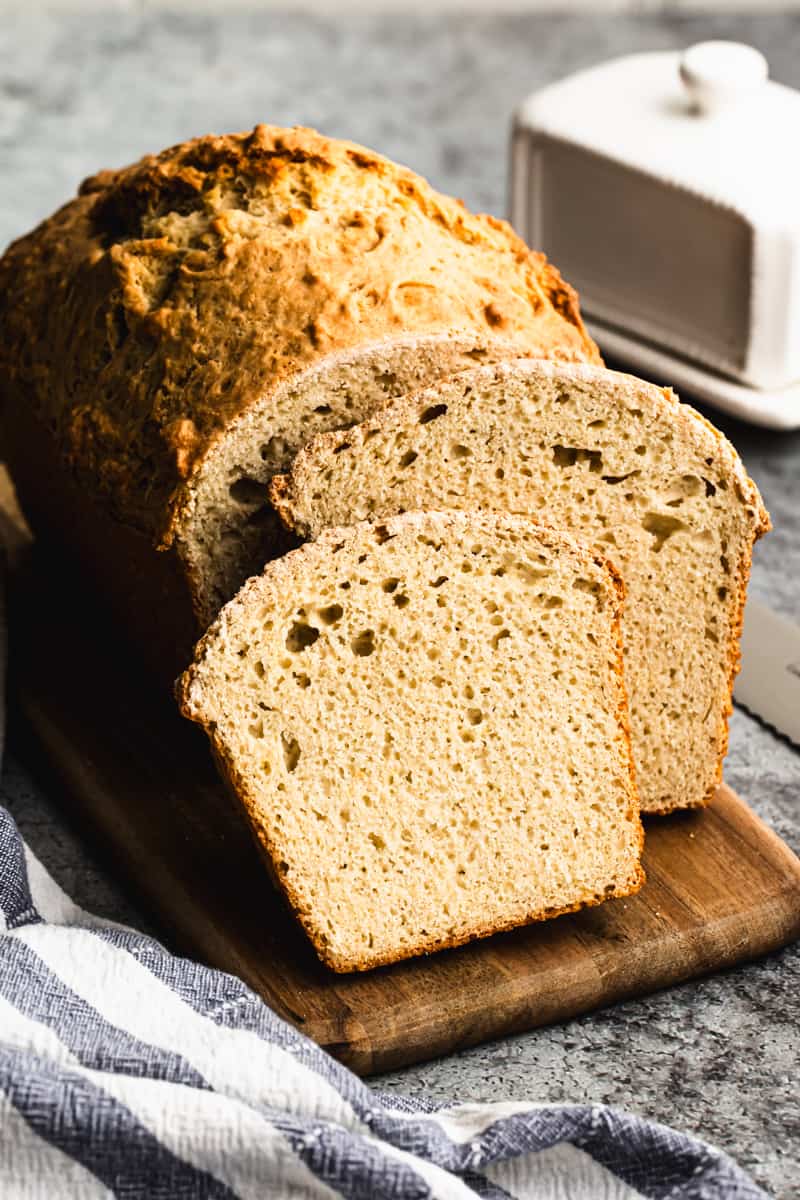 The best Beer Bread recipe on a cutting board, with a few slices sliced and ready to enjoy.