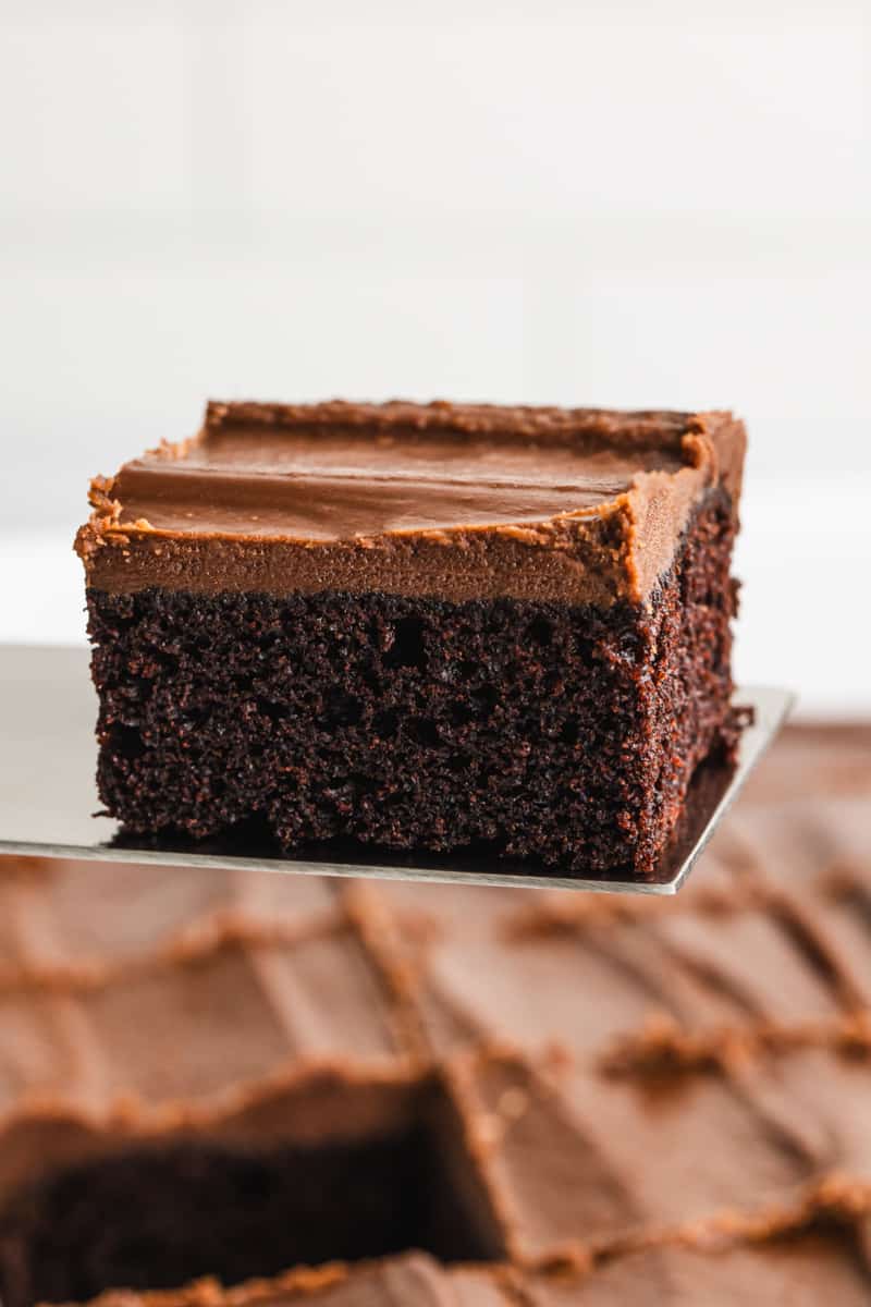 A moist piece of Chocolate Mayonnaise Cake being lifted by a spatula, ready to serve.