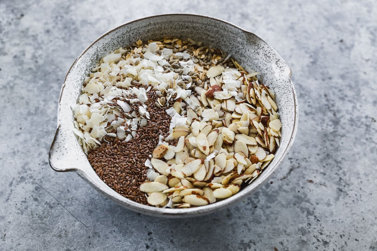 All of the dry ingredients needed and combined in a bowl to make a simple granola recipe.