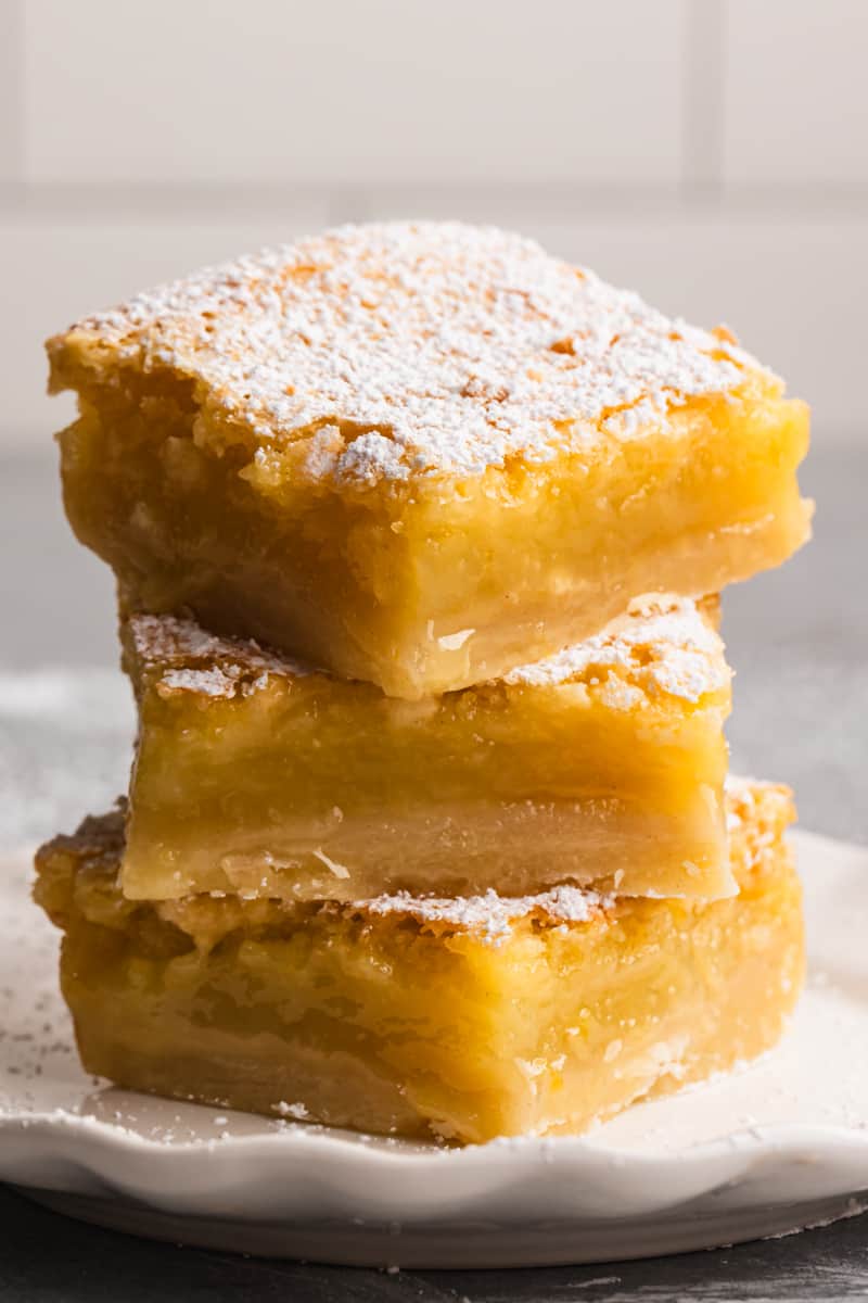 Three homemade lemon bars stacked on top of eachother.