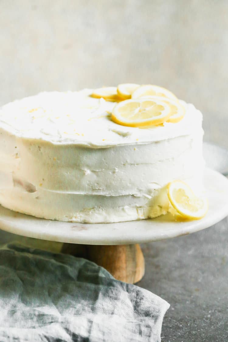 An easy lemon cake recipe with cake mix or homemade, with a lemon buttercream frosting and lemon slices for decoration.