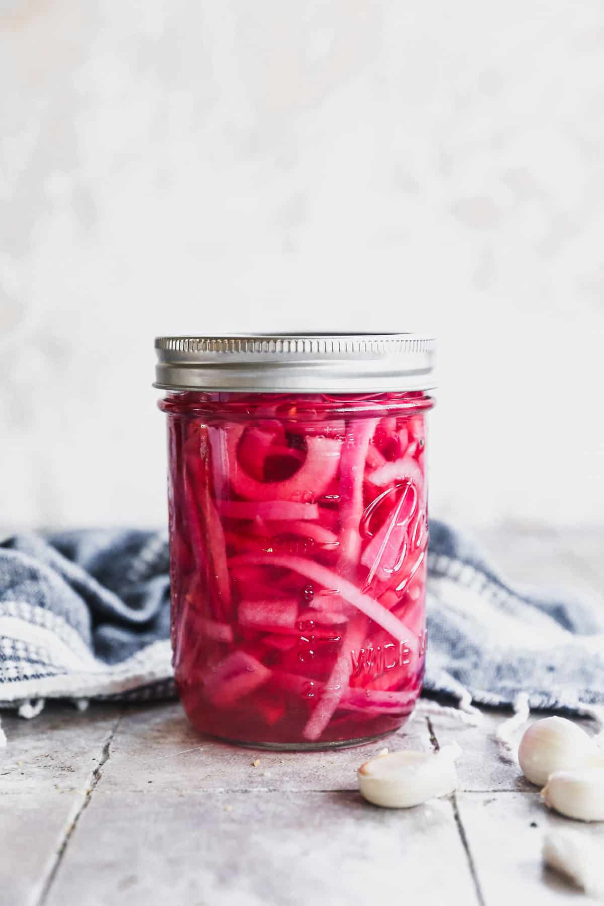 A quick Pickled Red Onions recipe in a mason jar, ready to enjoy or refrigerate.