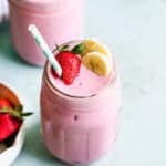 The best strawberry banana smoothie recipe with a strawberry, banana slices, and a straw ready to enjoy.