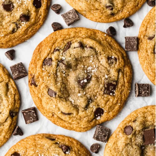 The best Browned Butter Chocolate Chip cookies recipe freshly baked on a piece of parchment paper, sprinkled with sea salt.