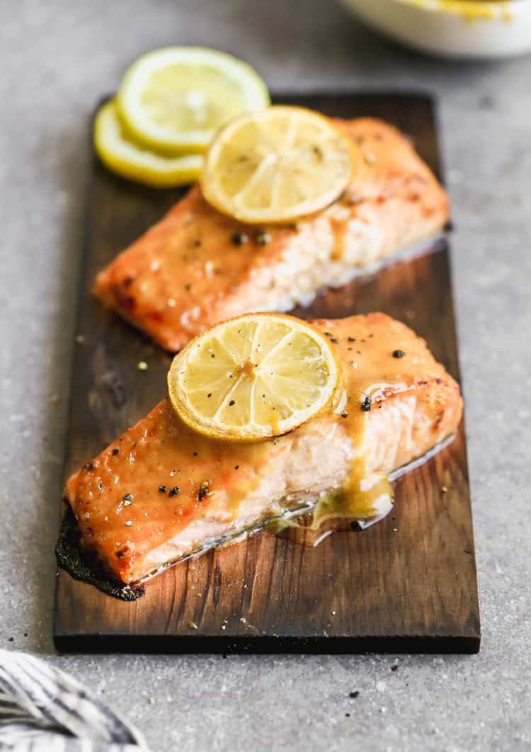 The best Cedar Plank Salmon recipe on a plank of cedar and topped with a brown sugar mustard glaze and a lemon on top. 