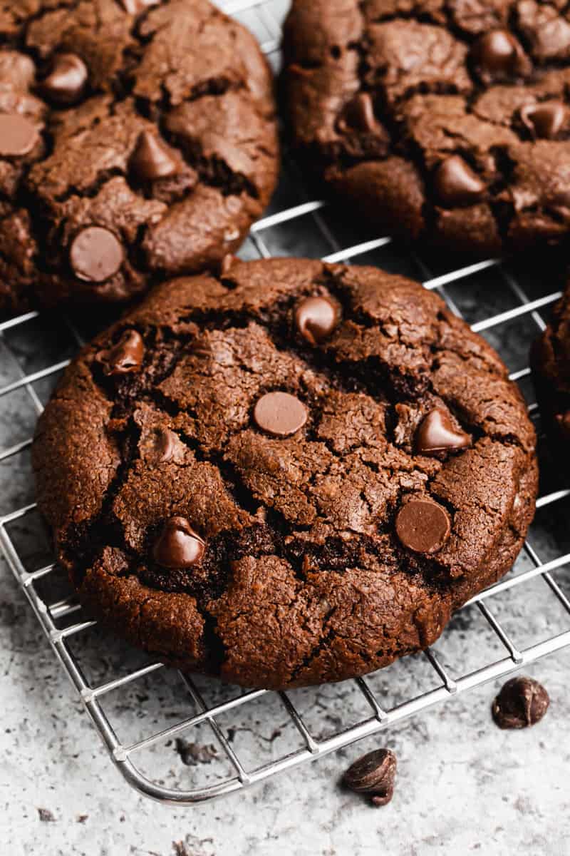 A big Double Chocolate Chip Cookie on a metal cooling rack, ready to enjoy.